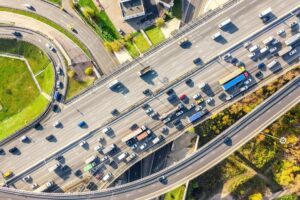 Vista aérea de rodovia com transportes rodoviários em cidade.